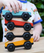 Four Bajo ToBe Poly cars wooden toys stacked up on top of each other.