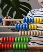 Close up of child playing with the Bajo 50 bead wide abacus in the Babipur playroom.