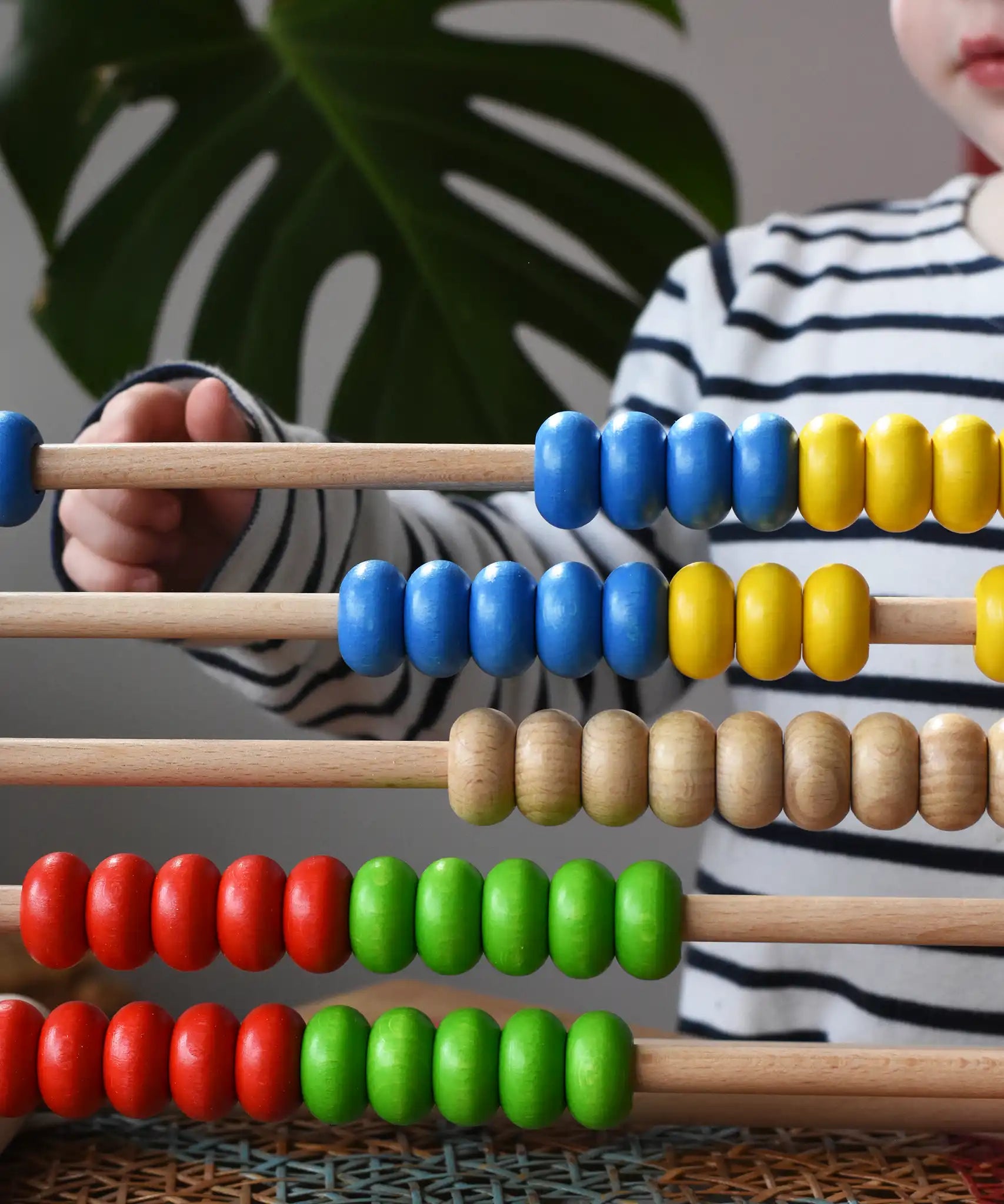 Close up of child playing with the Bajo 50 bead wide abacus in the Babipur playroom.