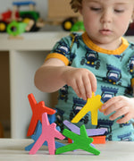 A child playing with the Bajo Acrobats balancing game. A set of 8 coloured wooden acrobat shaped figures. These heirloom quality toys by Bajo are part of a wide range of wooden toys available here at Babipur.