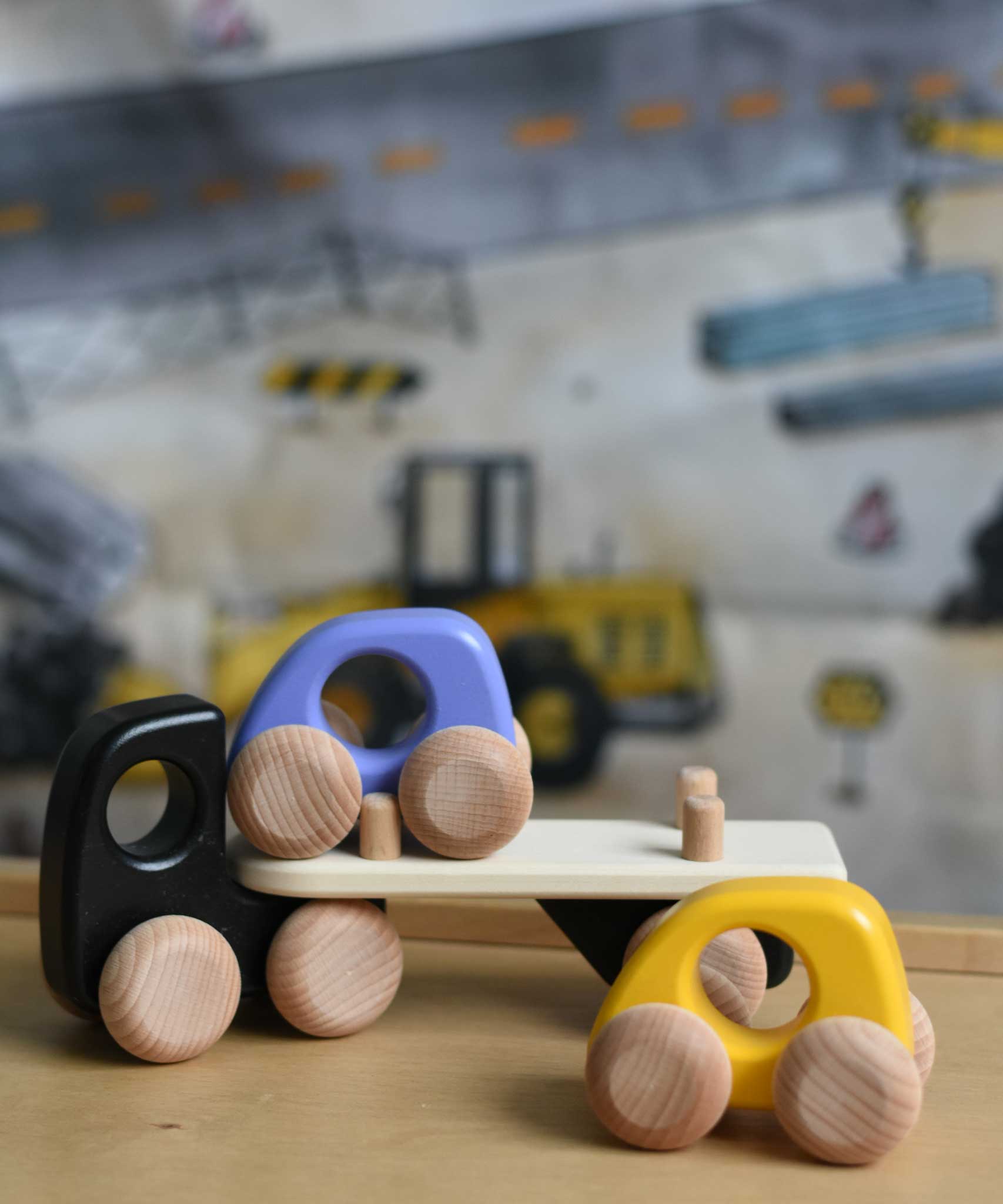 A black coloured Bajo Auto Transporter. The wooden toy car transporter comes with two cars, one purple and one yellow. These heirloom quality toys by Bajo are part of a wide range of wooden toys available here at Babipur. 