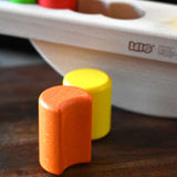 A close up of the orange moon shaped block from the Bajo Balance Scale wooden toy. A wooden base with a curved base with coloured wooden blocks that sit on top. These heirloom quality toys by Bajo are part of a wide range of wooden toys available here at Babipur.