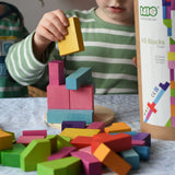 Bajo 43 wooden building blocks. 43 blocks, in 16 different shapes and 10 colours. Child stacking blocks on wooden lid of box.