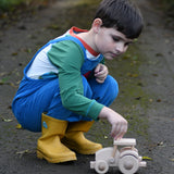 A child kneeling down next to wooden toy tractor made using the Bajo DIY tractor kit. These heirloom quality toys by Bajo are part of a wide range of wooden toys available here at Babipur. 