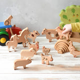 The figures from the Bajo farm animals set, set up in a play scene with a Bakop tractor and Holztiger oak tree in the background.