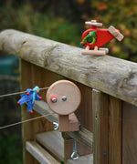 The Bajo Red Fire Engine Helicopter wooden toy used in a small world play scene with Kraul passenger felt dolls and the Kraul cable cars with basket kit. The red coloured wooden helicopter has natural propellers and stand and a blue lamp details on the front. These heirloom quality toys by Bajo are part of a wide range of wooden toys available here at Babipur. 