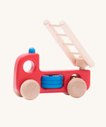 Bajo Fire Engine wooden toy vehicle. A red body truck with blue details on the body and roof with a natural wooden ladder and wheels.
