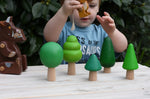 Child playing with the Gruffalo mouse figure in between the Bajo green forest tree set figures.