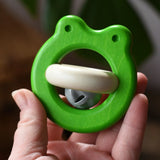 Bajo green Frog Rattle wooden baby toy in an adult's hand in the Babipur playroom