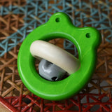 Bajo green Frog Rattle wooden baby toy placed on a rattan stool in the Babipur playroom.