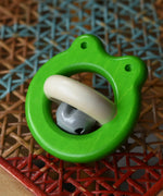 Bajo green Frog Rattle wooden baby toy placed on a rattan stool in the Babipur playroom.