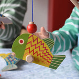 Bajo magnetic fishing game toy. Wooden rod with yellow and green fish attached.