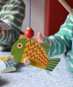 Bajo magnetic fishing game toy. Wooden rod with yellow and green fish attached.