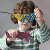 Bajo magnetic fishing game toy fish figure pieces in a child's hands.