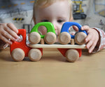 A child playing with a red coloured Bajo Auto Transporter. The wooden toy car transporter comes with two wooden toy cars. These heirloom quality toys by Bajo are part of a wide range of wooden toys available here at Babipur. 