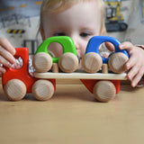 A child playing with a red coloured Bajo Auto Transporter. The wooden toy car transporter comes with two wooden toy cars. These heirloom quality toys by Bajo are part of a wide range of wooden toys available here at Babipur. 