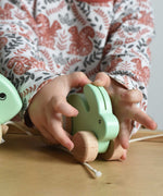 A close up of a mint green coloured small Bajo rabbit in a child's hands.  These heirloom quality toys by Bajo are part of a wide range of wooden toys available here at Babipur.