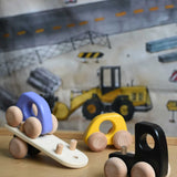 A black coloured Bajo Auto Transporter with the back detached from the trailer. The wooden toy car transporter comes with two cars, one purple and one yellow. These heirloom quality toys by Bajo are part of a wide range of wooden toys available here at Babipur. 