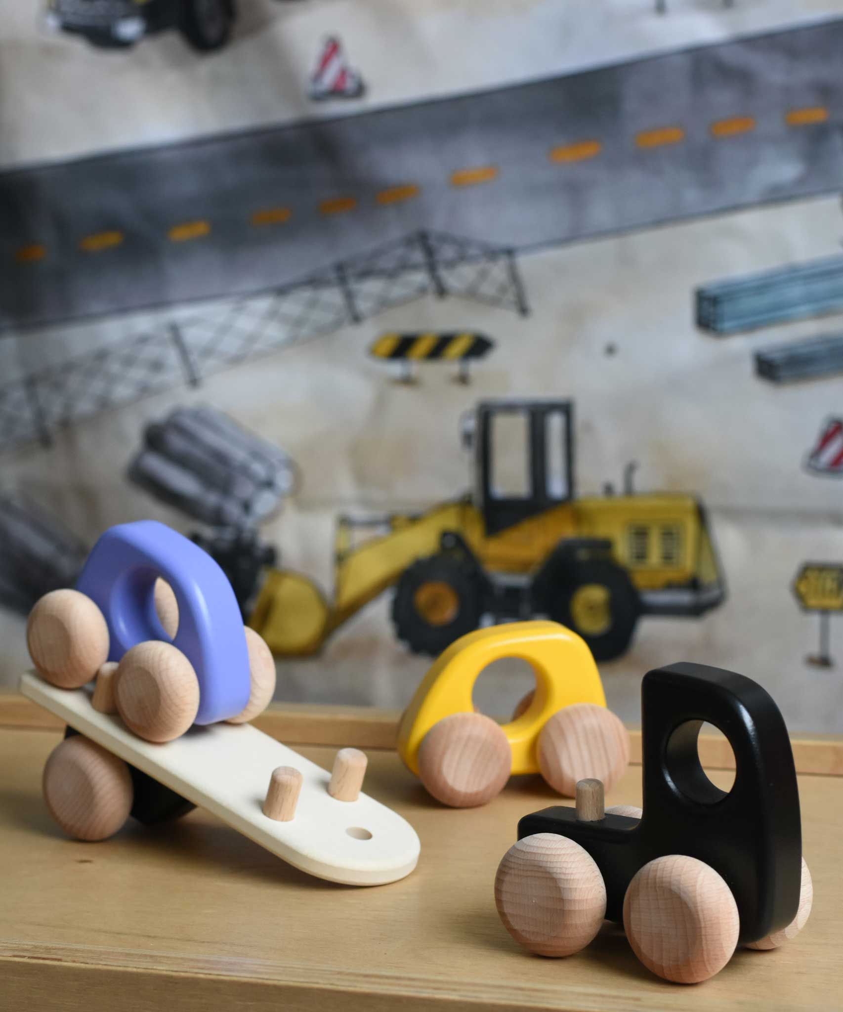 A black coloured Bajo Auto Transporter with the back detached from the trailer. The wooden toy car transporter comes with two cars, one purple and one yellow. These heirloom quality toys by Bajo are part of a wide range of wooden toys available here at Babipur. 