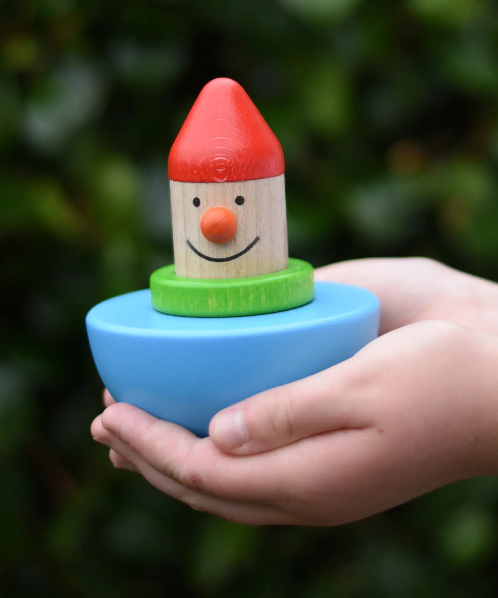 Bajo roly poly wobbling dwarf wooden baby toy in a child's hands