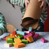 Bajo 43 wooden building blocks. 43 blocks, in 16 different shapes and 10 colours. Child tipping blocks from the sturdy cylinder shaped storage box.