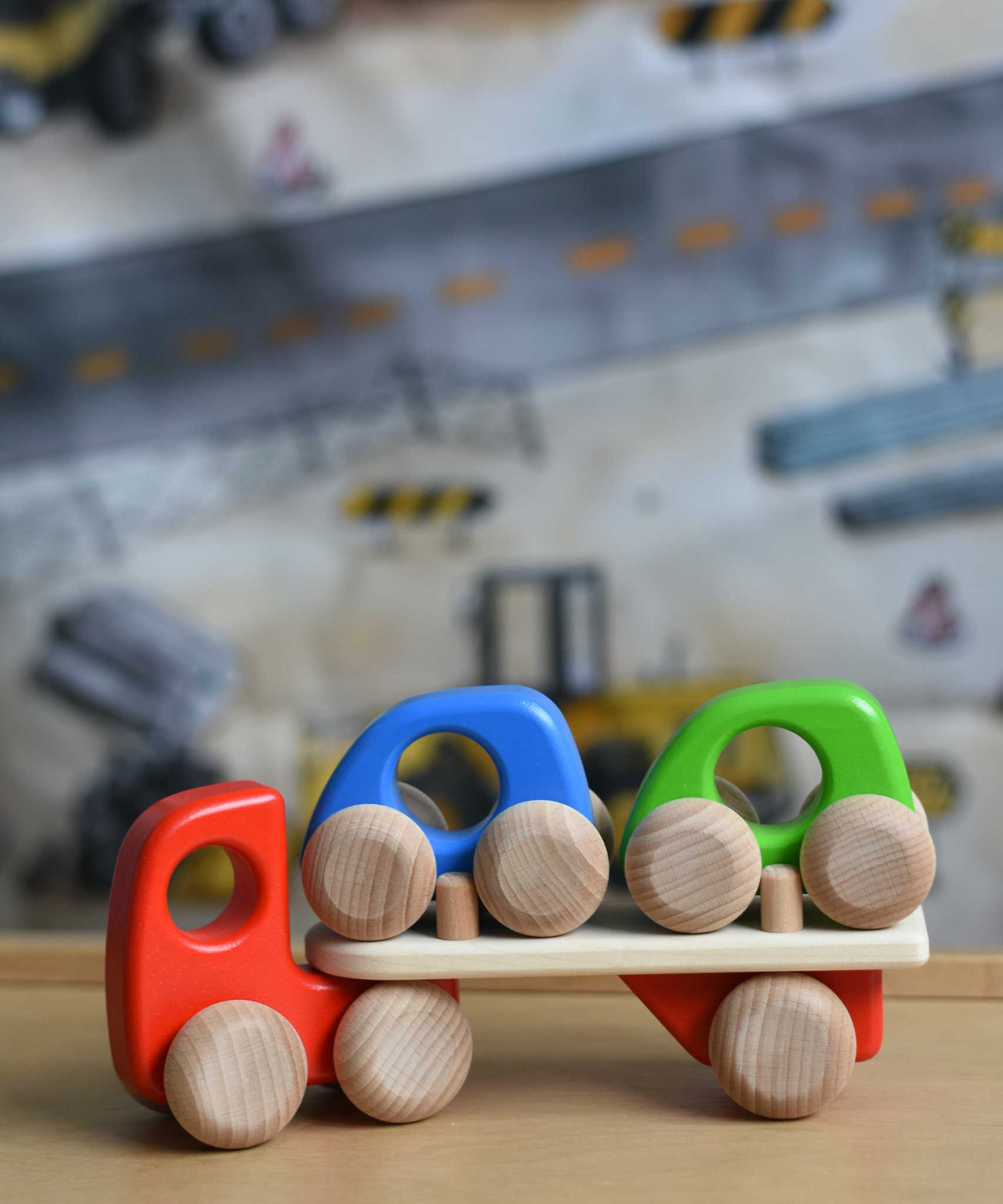 A red coloured Bajo Auto Transporter. The wooden toy car transporter comes with two toy cars. These heirloom quality toys by Bajo are part of a wide range of wooden toys available here at Babipur. 