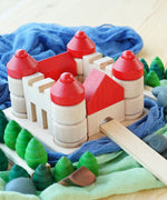 The Bajo Wooden Castle Stacker Toy shown in a small world play set up with Grapat mandala pieces and Ostheimer cloths.