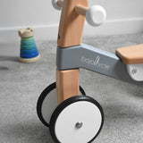 A close up of the front of the Bajo Toys wooden Cycle toddler Ride-On in the monochrome, white and grey colourway. The wheels are white with a black rubber outer.

The wooden ride on cycle is part of a wode range of wooden toys available here at Babipur. 