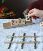 Bajo toys wooden easy maths learning set. Child placing wooden number tiles on the wooden stand.