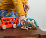 A child reaching for the Bajo Police Helicopter wooden toy. Other Bajo vehicles can be seen in the background. These heirloom quality toys by Bajo are part of a wide range of wooden toys available here at Babipur. 