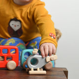 A child reaching for the Bajo Police Helicopter wooden toy. Other Bajo vehicles can be seen in the background. These heirloom quality toys by Bajo are part of a wide range of wooden toys available here at Babipur. 