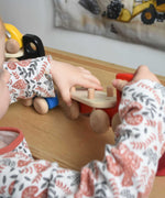 A close up a child playing with a red coloured Bajo Auto Transporter. The wooden toy car transporter comes with two cars, one green and one blue. These heirloom quality toys by Bajo are part of a wide range of wooden toys available here at Babipur. 