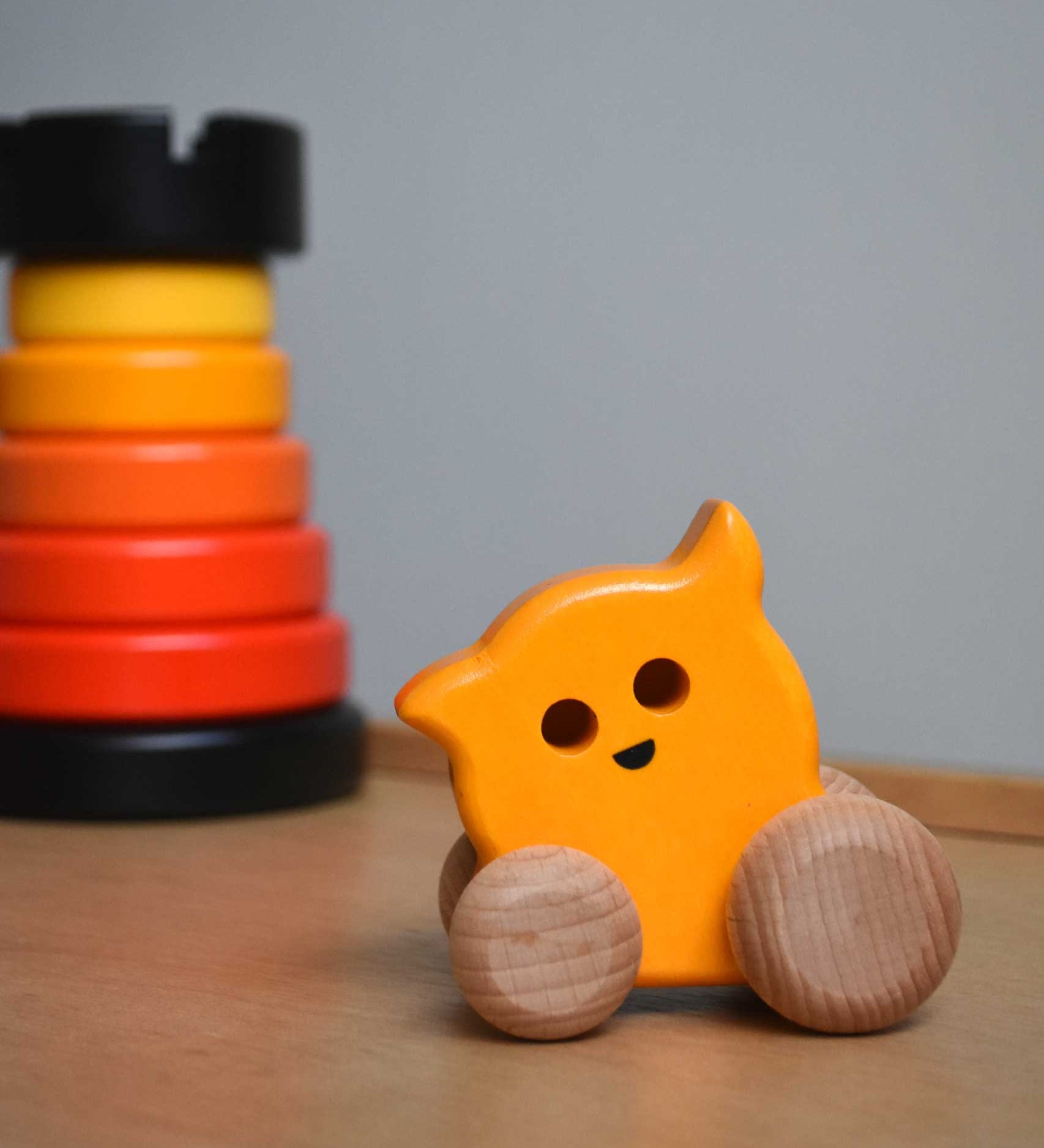 A Bajo push along eye ghost wooden toy placed on Triclimb Miri slide with a Bajo rook tower stacking toy in the background. These heirloom quality toys by Bajo are part of a wide range of wooden toys available here at Babipur. 