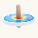 Bajo universe wooden spinning top toy blurred in motion as it spins around.