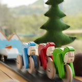 Bajo Velo cyclist toys shown racing along in a small world play scene. This wooden toy is part of a wide range of push along toys available at Babipur.
