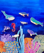 The wooden whale figures from the Bajo whale family puzzle shown placed on a Wonderie sea themed play cloth. These heirloom quality toys by Bajo are part of a wide range of wooden toys available here at Babipur. 