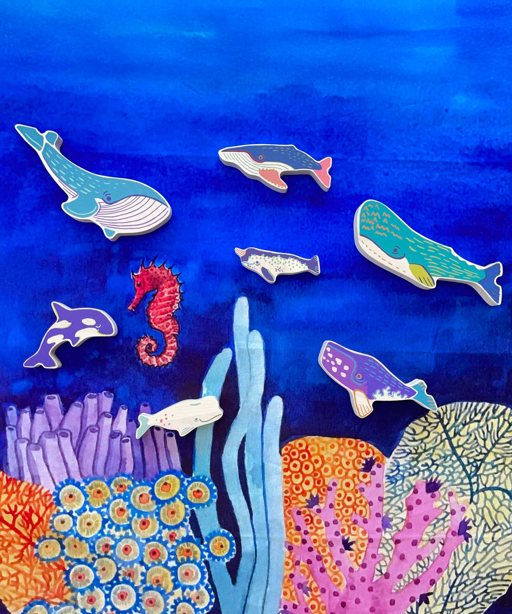 The wooden whale figures from the Bajo whale family puzzle shown placed on a Wonderie sea themed play cloth. These heirloom quality toys by Bajo are part of a wide range of wooden toys available here at Babipur. 