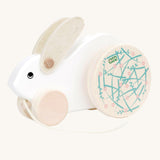 A white Bajo Big Rabbit toy. This pull along wooden toy has small wheels at the front and large decorated wheels at the back. The rabbit makes a jumping motion as it is being pulled along. We have a wide range of Bajo wooden toys available here at Babipur. 