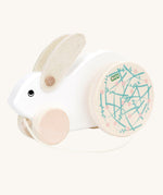 A white Bajo Big Rabbit toy. This pull along wooden toy has small wheels at the front and large decorated wheels at the back. The rabbit makes a jumping motion as it is being pulled along. We have a wide range of Bajo wooden toys available here at Babipur. 