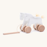 Bajo hand made wooden jumping horse in white and.available at Babipur. Features unpainted wheels  and a toggle to pull along the horses