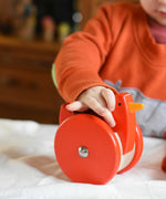 A child playing with the A child playing with the Bajo Red Wobbling Chicken. A red push along wooden chicken toy that bob up and down when pushed along.  These heirloom quality toys by Bajo are part of a wide range of wooden toys available here at Babipur.