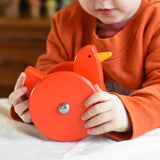 A child playing with the Bajo Red Wobbling Chicken. A red push along wooden chicken toy that bob up and down when pushed along.  These heirloom quality toys by Bajo are part of a wide range of wooden toys available here at Babipur.
