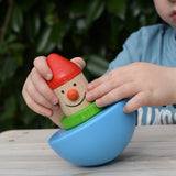 Child playing with Bajo roly poly wobbling dwarf wooden baby toy.