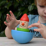 Child playing with Bajo roly poly wobbling dwarf wooden baby toy.