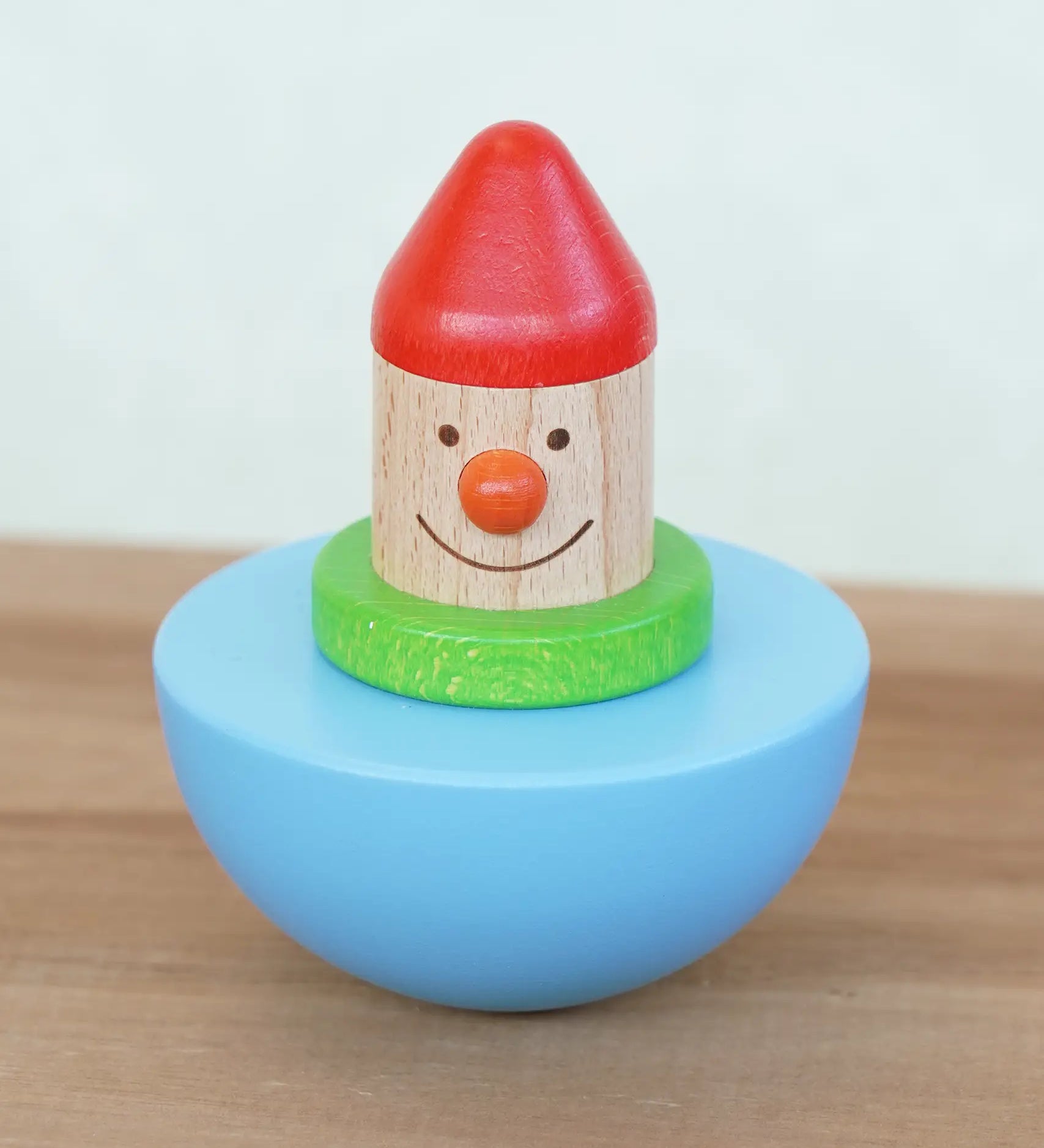 Bajo roly poly wobbling dwarf wooden baby toy. Blue half sphere base that wobbles when pushed with a wooden dwarf character on top from Babipur