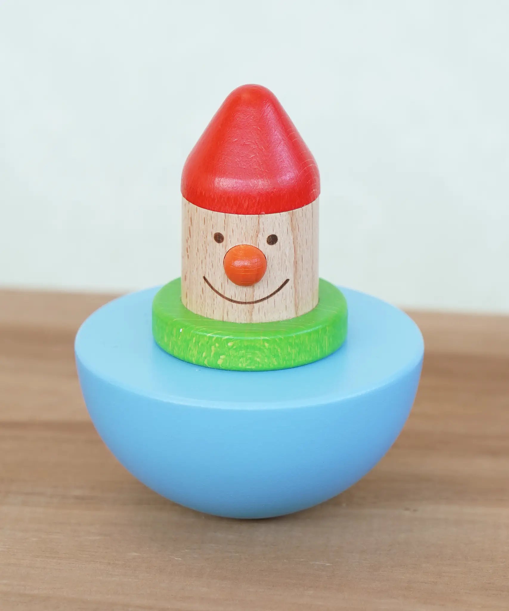 Bajo roly poly wobbling dwarf wooden baby toy. Blue half sphere base that wobbles when pushed with a wooden dwarf character on top from Babipur