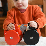 A child playing with the Bajo Red Wobbling Chicken and wobbling penguin toy. A red push along wooden chicken toy that bob up and down when pushed along.  These heirloom quality toys by Bajo are part of a wide range of wooden toys available here at Babipur.