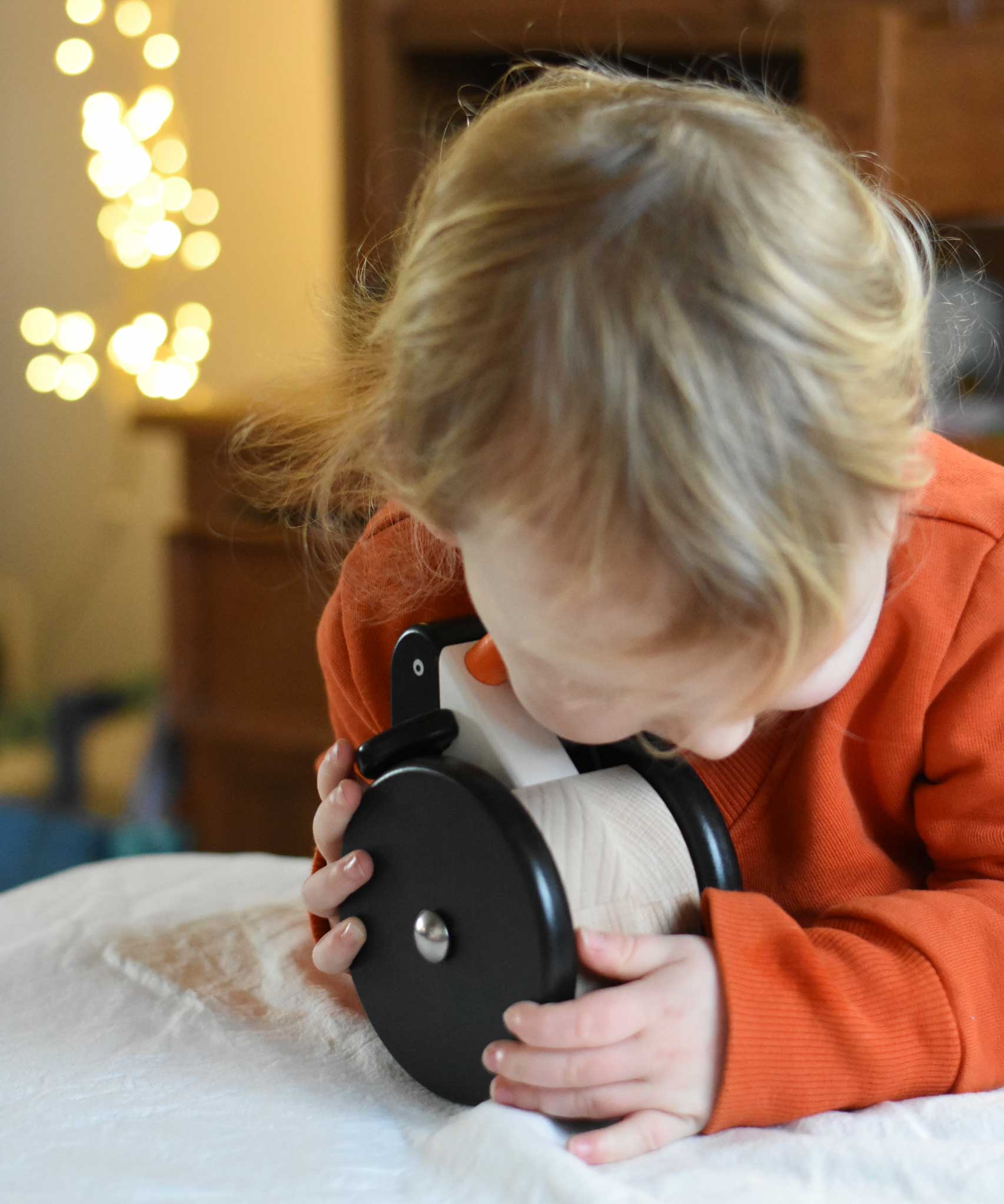 A child cuddling the Bajo wobbling penguin push along wooden toy. This toy penguin has large black wheels. These heirloom quality toys by Bajo are part of a wide range of wooden toys available here at Babipur. 