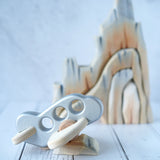 A silver coloured Bajo airplane pictured resting on a piece of the Bumbu Cliffs
