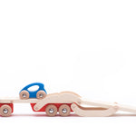 Bajo eco-friendly wooden auto transporter lorry with its trailer lowered and two blue cars driving up on a white background